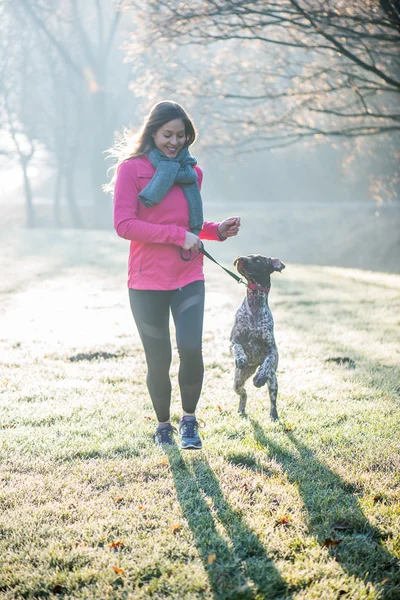 Runner vrouw en haar schattige Duitse aanwijzer hond samen uitgevoerd buiten op het mooie park. — Stockfoto