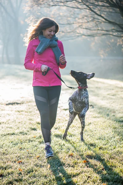 Futó nő és lány aranyos német mutató kutya fut össze a gyönyörű Park szabadtéri. — Stock Fotó