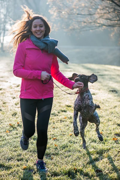 Runner femme et son chien pointeur allemand mignon courir ensemble en plein air au beau parc . — Photo