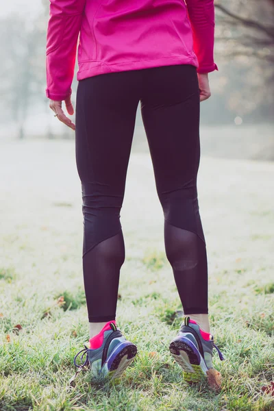 Biegacz kobieta nogi na zimowym torze, pojęcie zdrowego stylu życia — Zdjęcie stockowe
