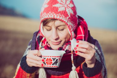 Kış kızı ısınmak için çay ya da kahve içiyor..