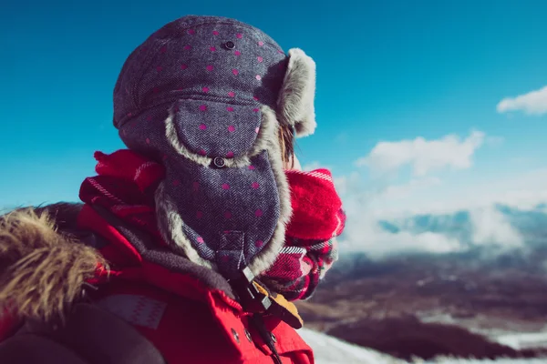 Junger Entdecker blickt gegen blauen Himmel, warme Mütze und Schal — Stockfoto