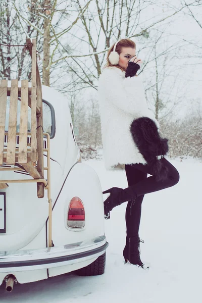 Junge Frau trinkt heißen Tee oder Kaffee im Freien, vintage Winterurlaub Konzept — Stockfoto
