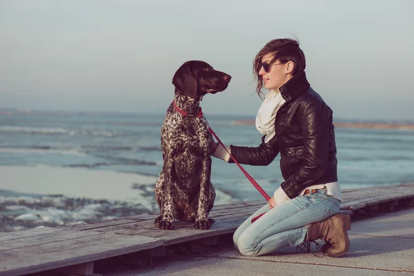Młoda kobieta pociąg jej wskaźnik niemiecki pies zewnątrz — Zdjęcie stockowe