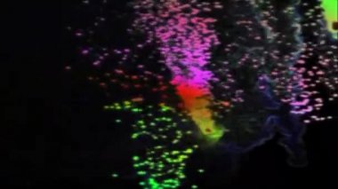 Siyah bir arka plan üzerinde renkli parçacıkların animasyonlu açılan