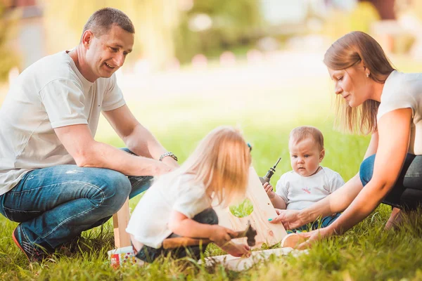 Familia feliz con pajarera de madera —  Fotos de Stock