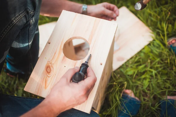 Mannelijke handen met houten birdhouse — Stockfoto