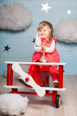 Ahşap oyuncak uçak içinde oturan küçük kız