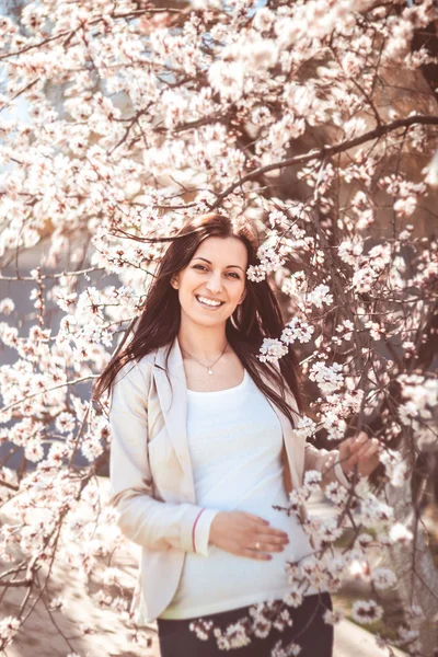 Pregnant woman in the flowering branches — Stock Photo, Image