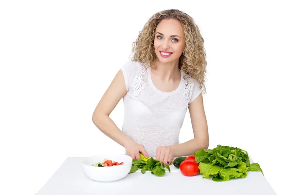 Woman making salad in kitchen. Royalty Free Stock Images