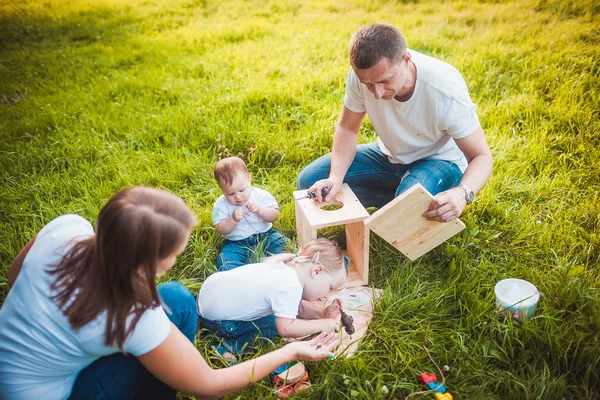 Familia feliz con pajarera de madera —  Fotos de Stock