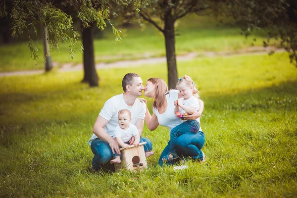 Glückliche Familie mit hölzernem Vogelhaus — Stockfoto