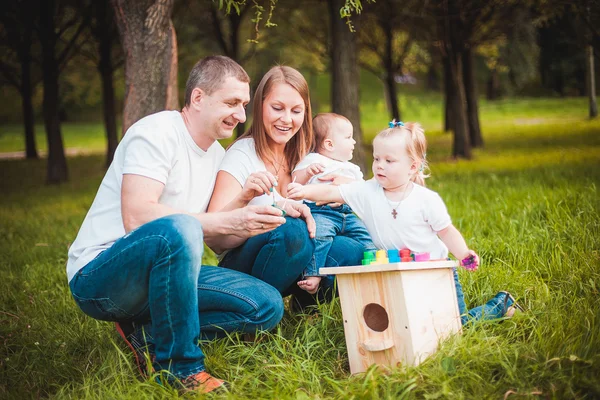 Šťastná rodina s hnízdící box a barvy — Stock fotografie