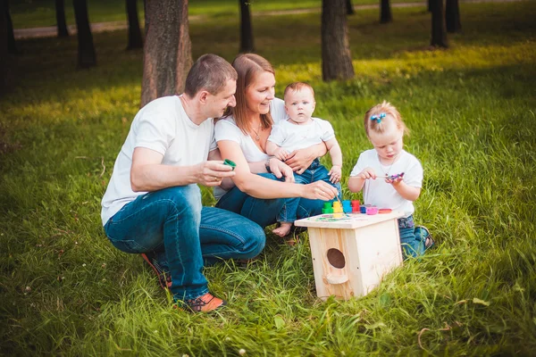 Šťastná rodina s hnízdící box a barvy — Stock fotografie