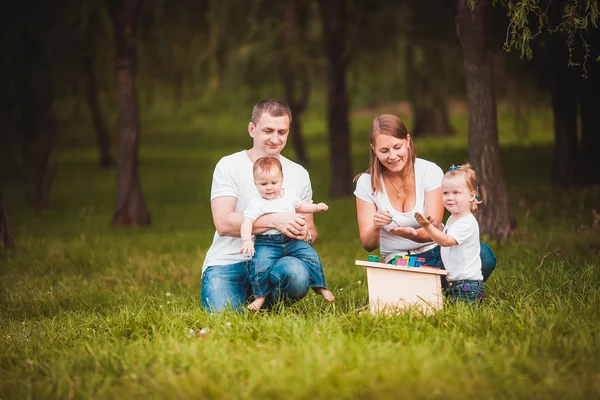 Happy family with nesting box and paints — Stock Photo, Image