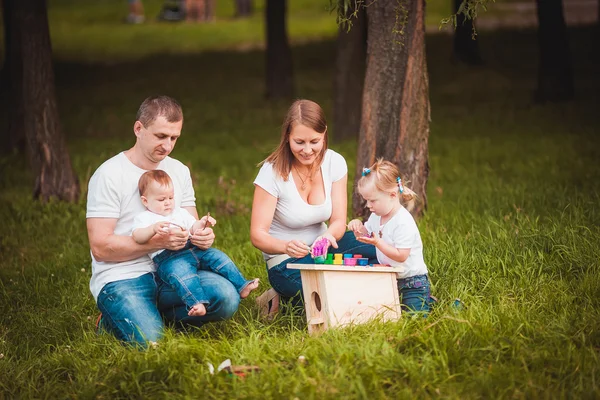 Família feliz com caixa de nidificação e tintas — Fotografia de Stock