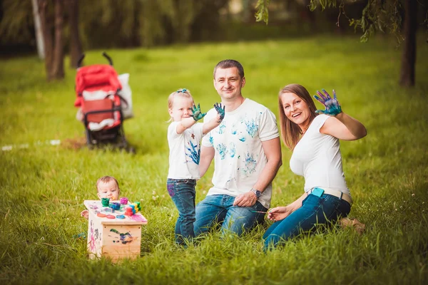 Família feliz com caixa de nidificação e tintas — Fotografia de Stock