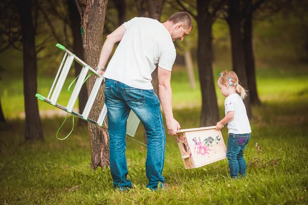 Met houten birdhouse en gelukkige familie — Stockfoto