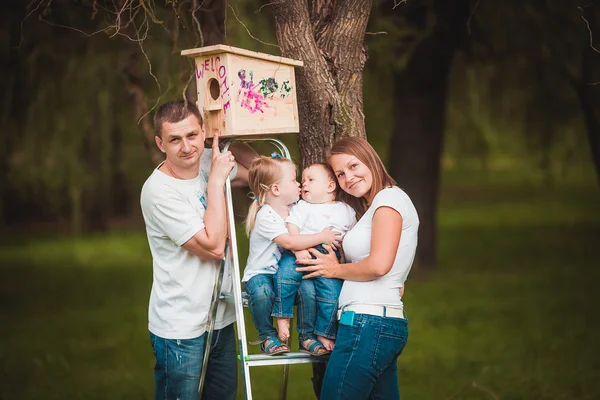 Šťastná rodina s dřevěnými holubník — Stock fotografie