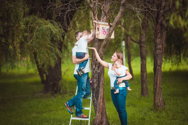 Familia feliz con pajarera de madera — Foto de Stock