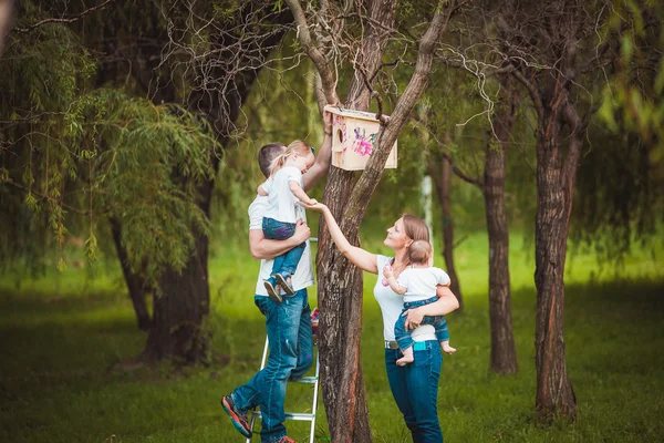 Happy family with Wooden birdhouse — Stock Photo, Image