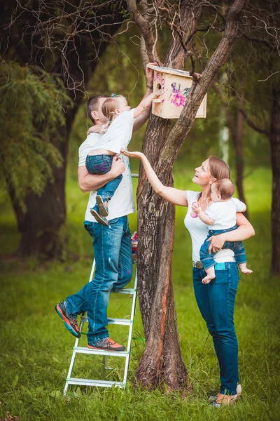 Glückliche Familie mit hölzernem Vogelhaus — Stockfoto