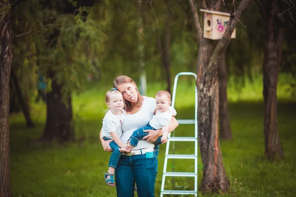 Mutter und ihre Töchter mit hölzernem Vogelhaus — Stockfoto