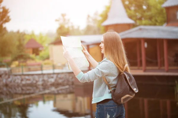 Chica viajero en busca de la dirección correcta en el mapa, luz naranja puesta del sol, viajando por Europa — Foto de Stock