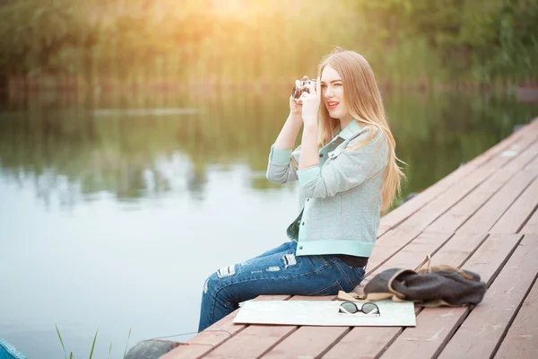 En pen ung kvinne som reiser med fotokamera og lager bilder – stockfoto