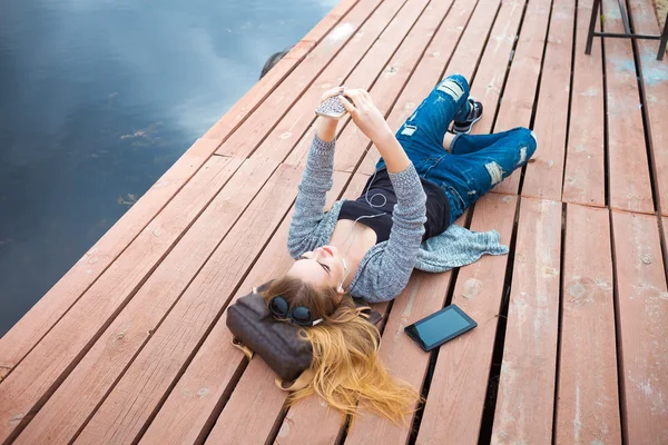 Jeune femme relaxant sur quai — Photo