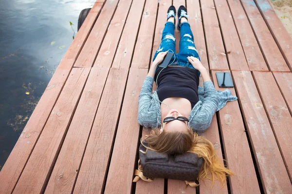 Jeune femme relaxant sur quai — Photo