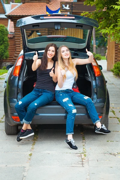 Two girls posing in car