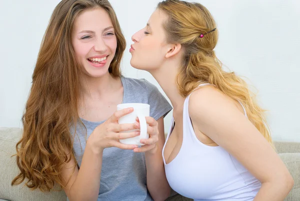 Two happy friends drinking coffee or tea and gossioing — Stock Photo, Image