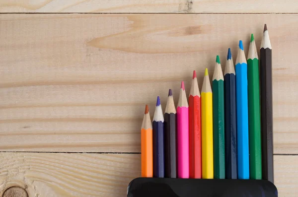 Lápices de colores en una tabla de madera — Foto de Stock