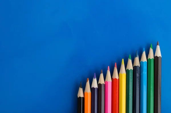 Цветные карандаши на синем фоне — стоковое фото