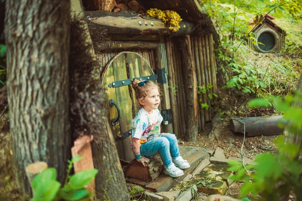 Девочка рядом с крошечным домом — стоковое фото