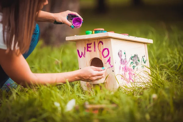 Meisje schilderij birdhouse — Stockfoto