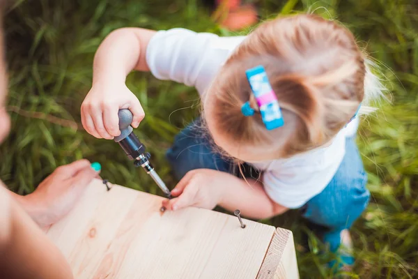 Lilla flickan att göra trä fågelholk — Stockfoto