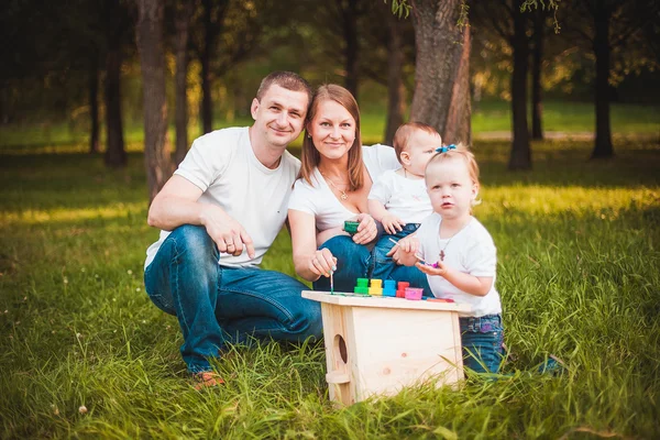 Ευτυχισμένη οικογένεια με ένθεσης κουτί και χρώματα — Φωτογραφία Αρχείου