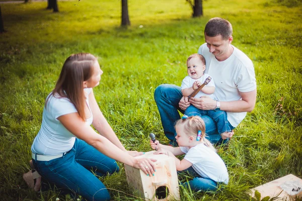 Familia feliz con pajarera de madera —  Fotos de Stock