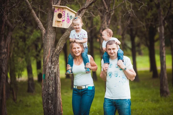 Familia feliz con pajarera de madera —  Fotos de Stock