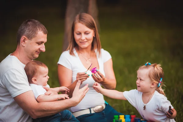 Familia feliz con caja de anidación y pinturas —  Fotos de Stock