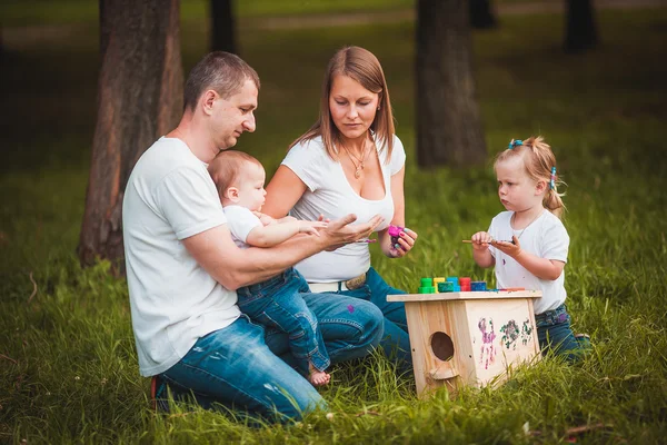 Familia feliz con caja de anidación y pinturas —  Fotos de Stock