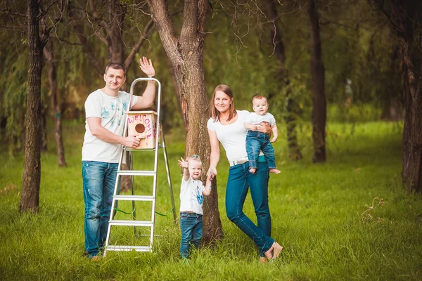 Happy family with Wooden birdhouse — Stock Photo, Image