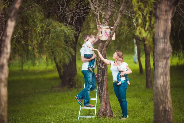 Happy family with Wooden birdhouse — Stock Photo, Image