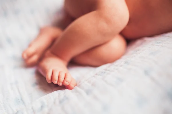 Piedi del bambino sulla coperta bianca — Foto Stock