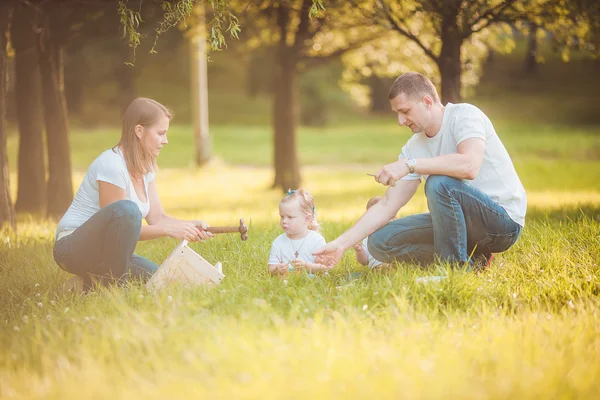 Lykkelig familie med træ birdhouse - Stock-foto