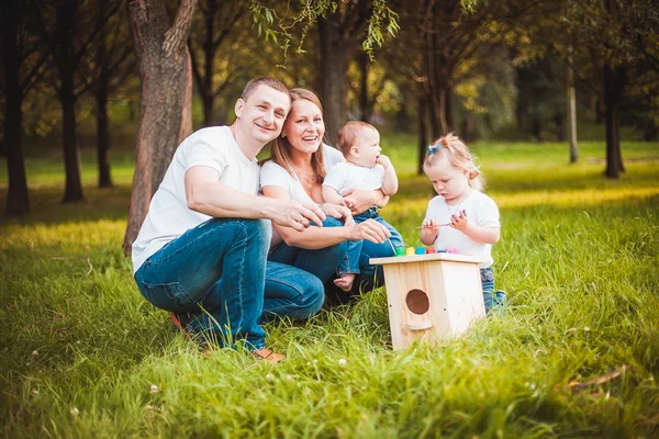 Glückliche Familie mit Nistkasten und Farben — Stockfoto