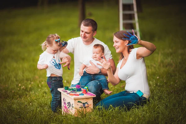 Família feliz com caixa de nidificação e tintas — Fotografia de Stock