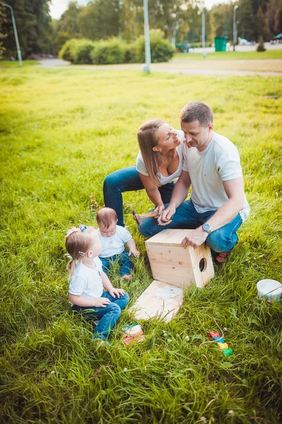 Šťastná rodina s hnízdící box a barvy — Stock fotografie